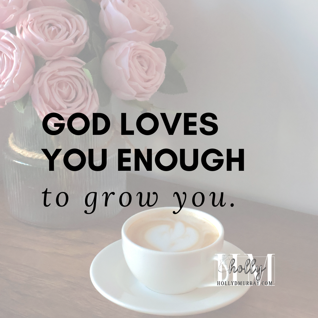 A cozy ceramic coffee cup with steam rising, sitting on a wooden table next to a bouquet of fresh spring flowers. The cup features inspirational typography text that reads, 'God Loves You Enough To Grow You.' This photo represents faith-based growth and finding comfort in difficult seasons.